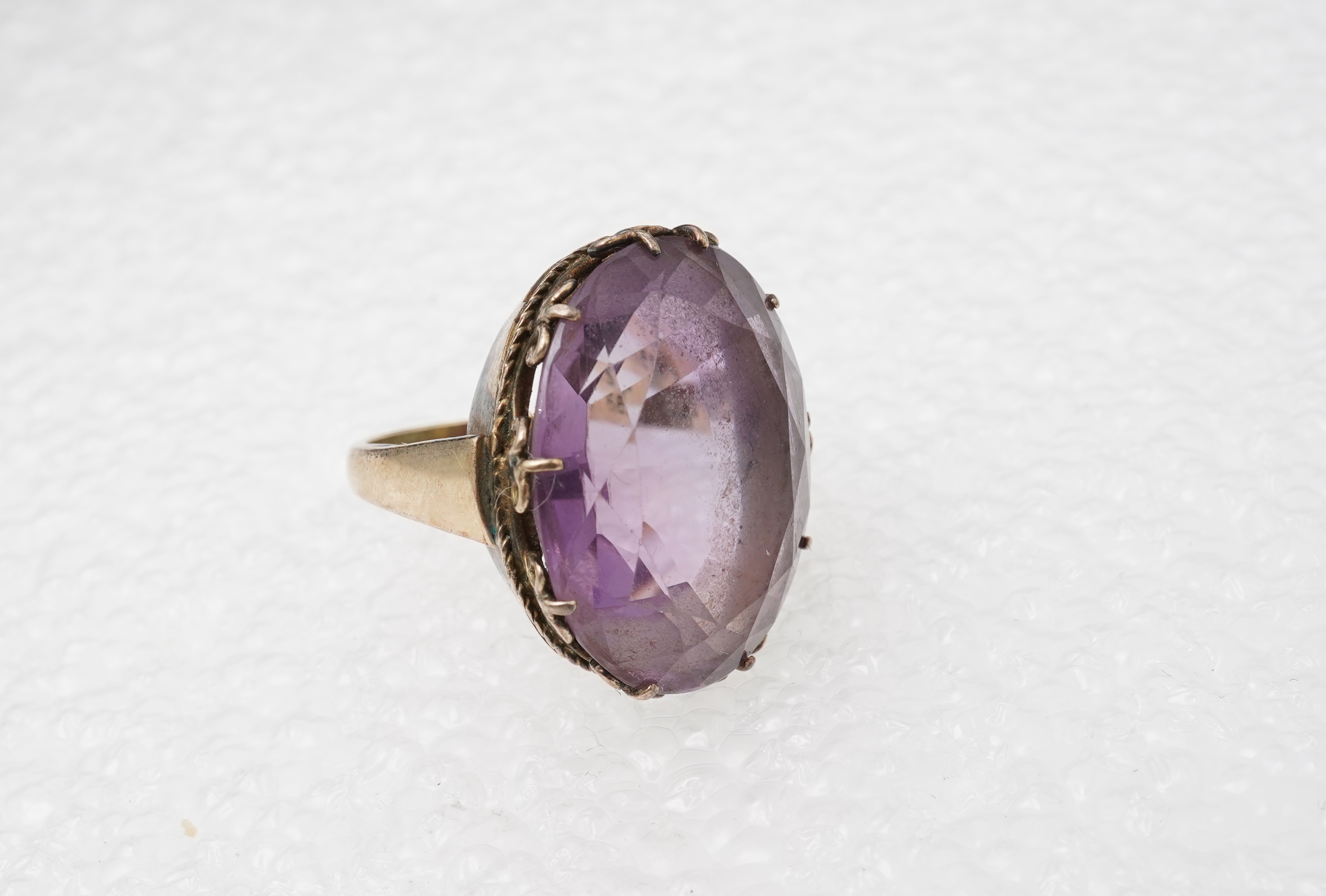 An amethyst ring, necklace and pendant, comprising: an oval amethyst set in a floral gilt silver necklace, length 32cm; an oval amethyst and seed pearl pendant, length 3.7cm; and a ring set with an oval amethyst, mounted